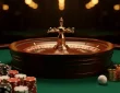 A roulette wheel with chips and coins on a green casino table