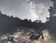 Night sky filled with stars over a rocky landscape