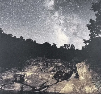 Night sky filled with stars over a rocky landscape