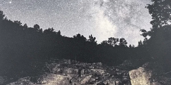 Night sky filled with stars over a rocky landscape